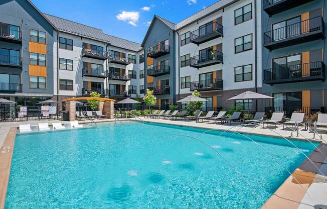 A swimming pool in front of apartment buildings.