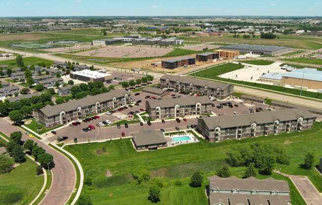 an aerial view of an apartment complex with cars parked in a parking lot