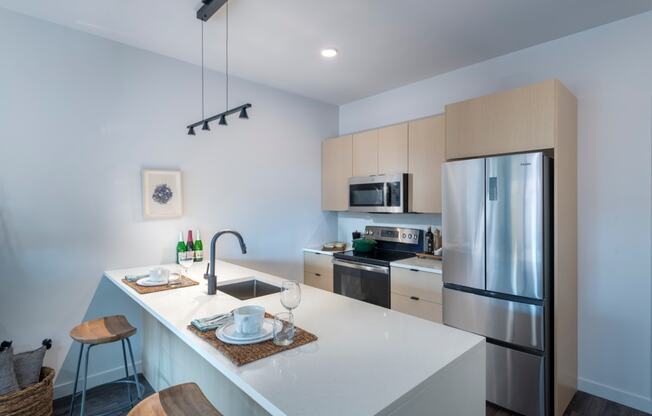 a kitchen with a large island and stainless steel refrigerator