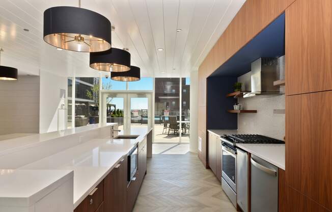 a kitchen with white countertops and stainless steel appliances and a blue accent wall