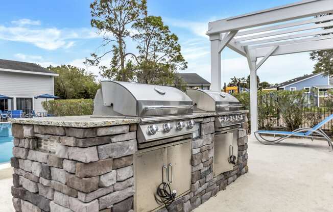 an outdoor kitchen with two stainless steel appliances and a grill