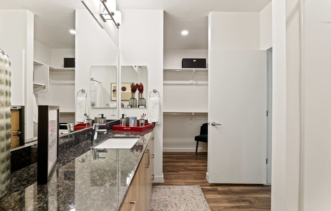 a kitchen with granite countertops and a sink and a door to a living room