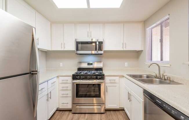 A kitchen with white cabinets and stainless steel appliances.
