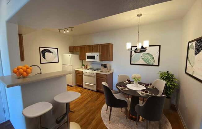 A kitchen with a dining table and chairs.