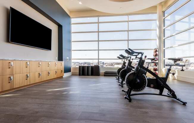 a gym with a large window and a row of exercise bikes in front of it