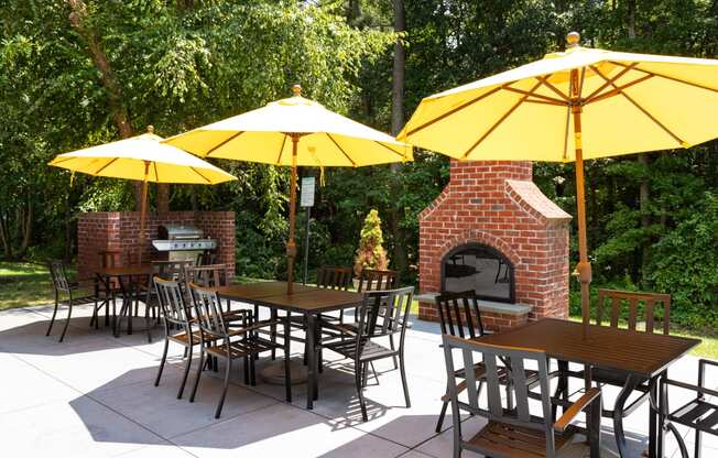 a patio with yellow umbrellas and a barbecue