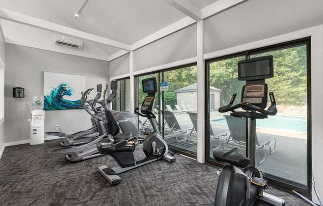 A room with a treadmill, exercise bike, and other equipment.