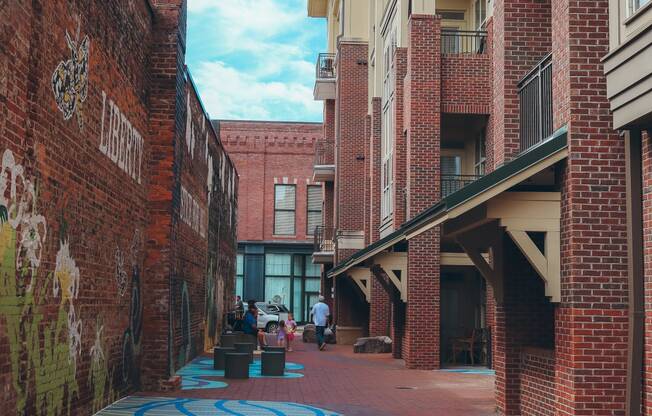 a city street with brick buildings and a blue mural on the ground