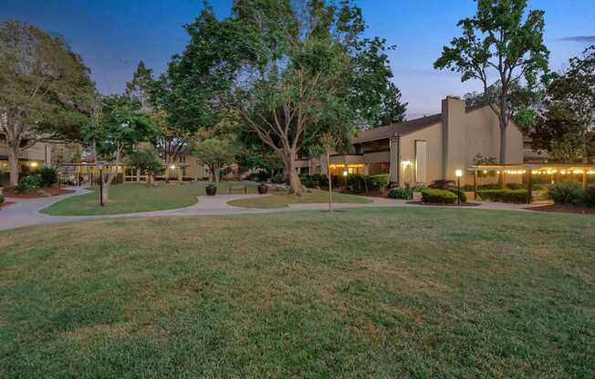 a building with trees and grass in front of it at Summerwood Apartments, Santa Clara, CA