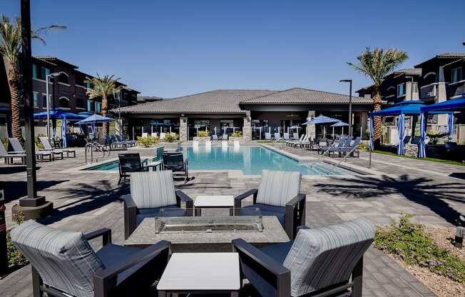 A poolside area with lounge chairs and a fire table.