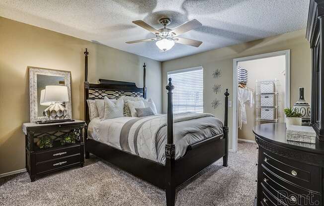 A bedroom with a bed, dresser, and mirror.