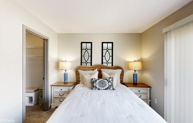 a bedroom with a bed and two lamps and a closet