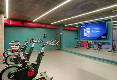 a gym with bikes and a projection screen on the wall