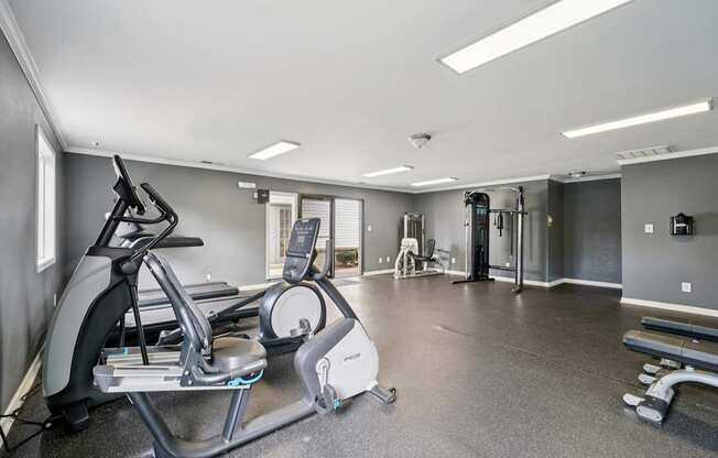 A spacious gym with a treadmill, elliptical trainer, and other exercise equipment.