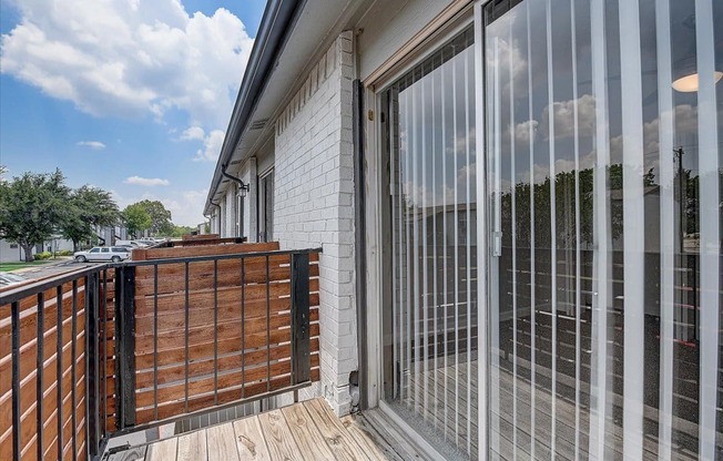 a balcony with white brick walls and a wooden deck