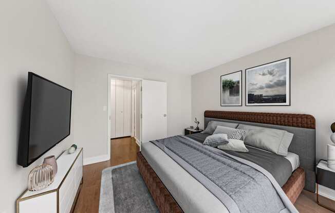 a bedroom with a bed and a tv on the wall