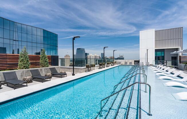 Rooftop pool with clear sightlines, in-water loungers, and surrounding city views creating a polished place to cool off and recharge.