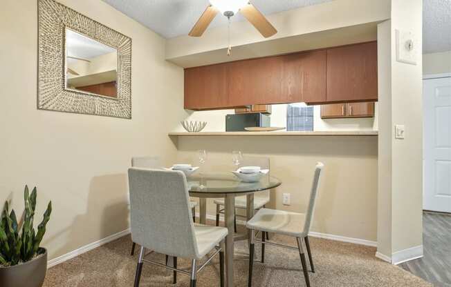 a dining area with a table and chairs and a ceiling fan