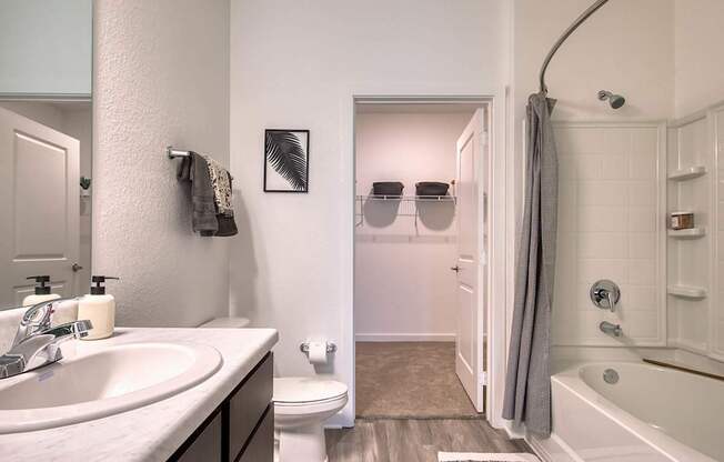 A bathroom with a white tub and a white toilet.