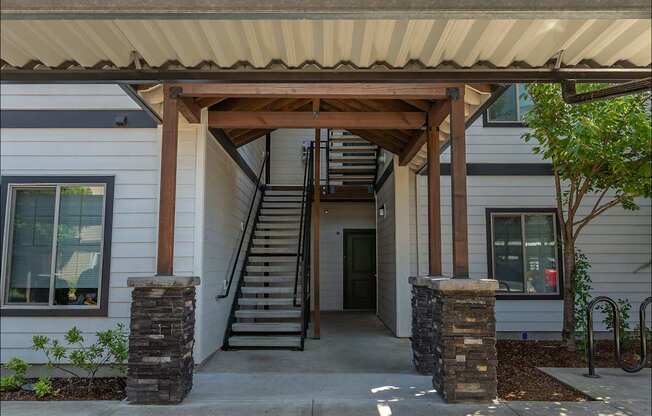 A white house with a brown roof and a wooden porch at Forestplace Apartment Homes, Oregon