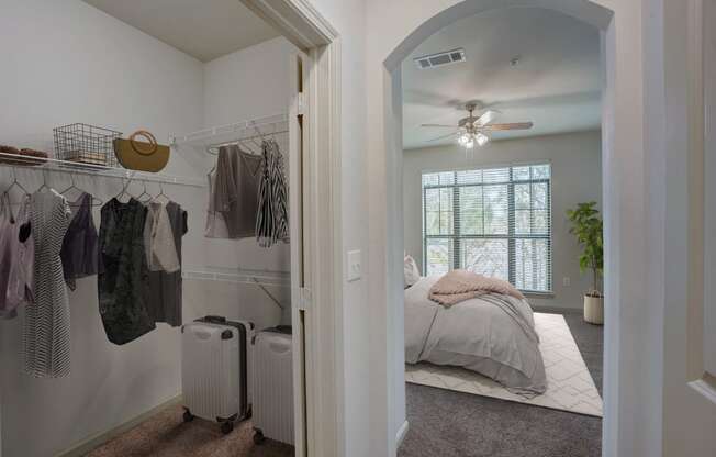 a bedroom with a closet and a bed and a ceiling fan