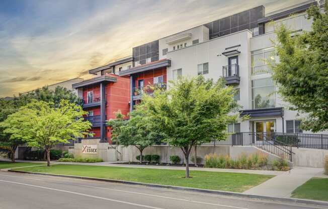 an apartment building on a city street with trees