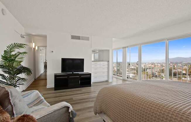 A bedroom with a large bed and a flat screen TV.