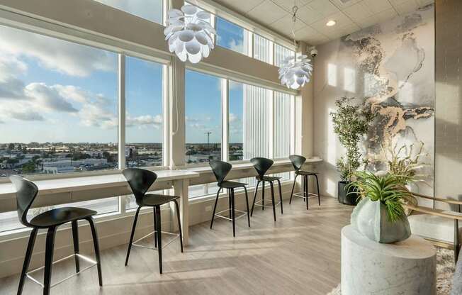 A room with a view of the city through large windows.