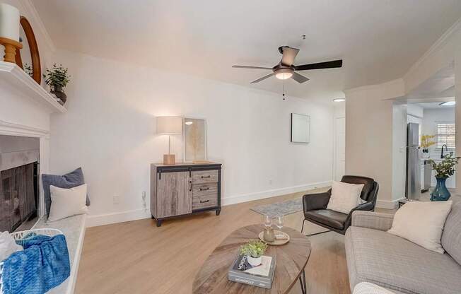 A living room with a fireplace and a grey couch.