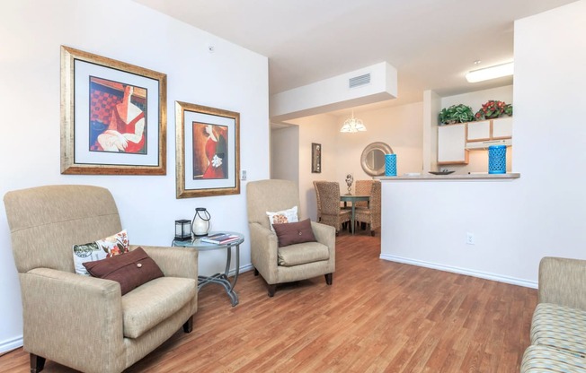 a living room with couches and chairs and a kitchen with a dining room table