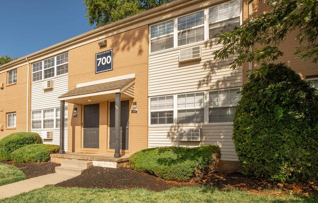 a large brick building with grass in front of a house