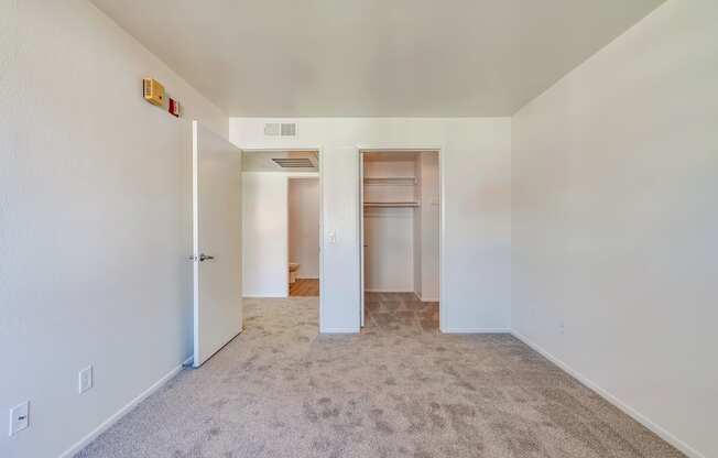 a bedroom with white walls and carpet