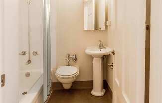 A bathroom with a sink, toilet and bathtub at Addison on Fourth Apartments, Seattle