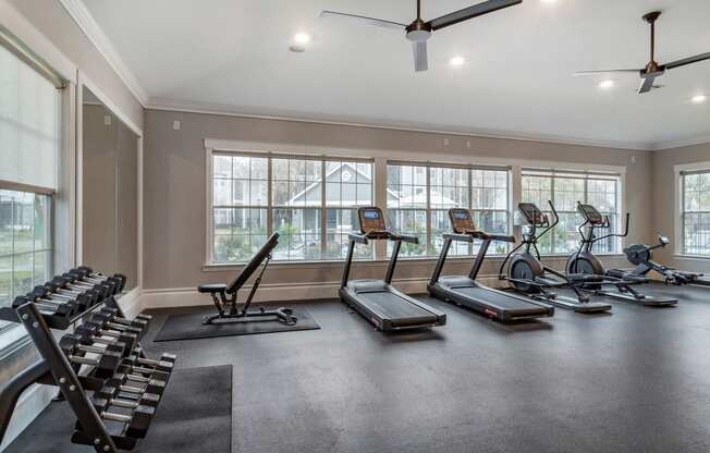 a gym with treadmills and other exercise equipment and windows at Reserve by the Lake, Houston, Texas