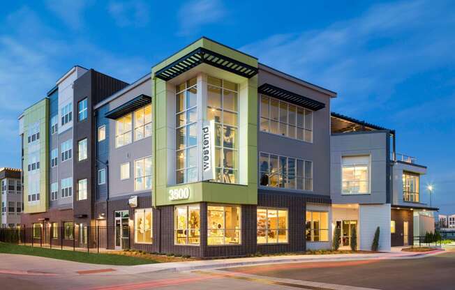Exterior image of Westend Apartments building lit up at night time.
