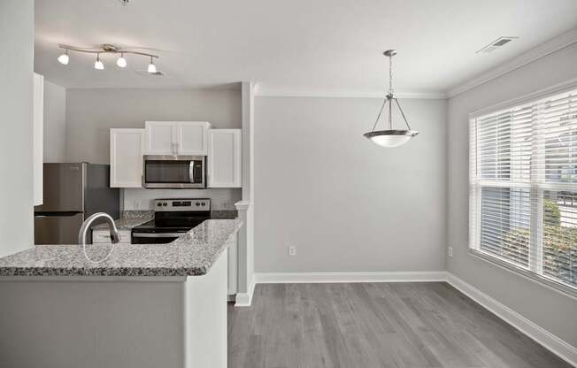 A kitchen with granite countertops and white cabinets.