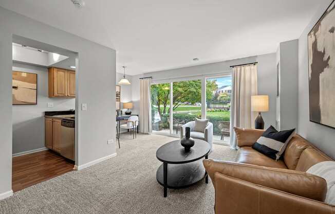 A living room with a brown leather couch and a grey coffee table.