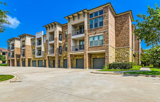 a large apartment building with a driveway and trees at Discovery at Craig Ranch, McKinney