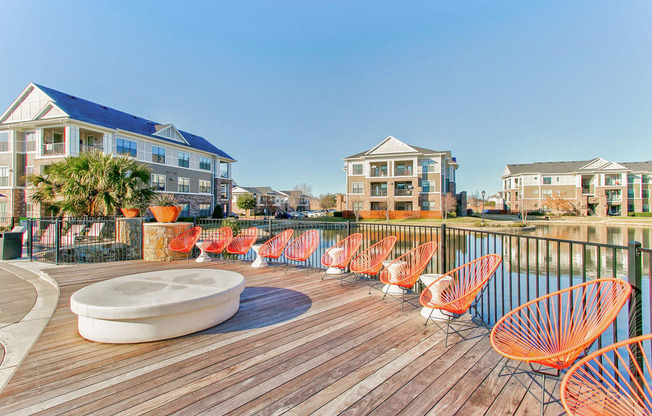 wooden deck with lounge chairs and pond in background