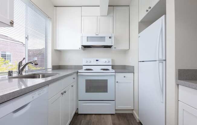 a kitchen with white appliances and white cabinets