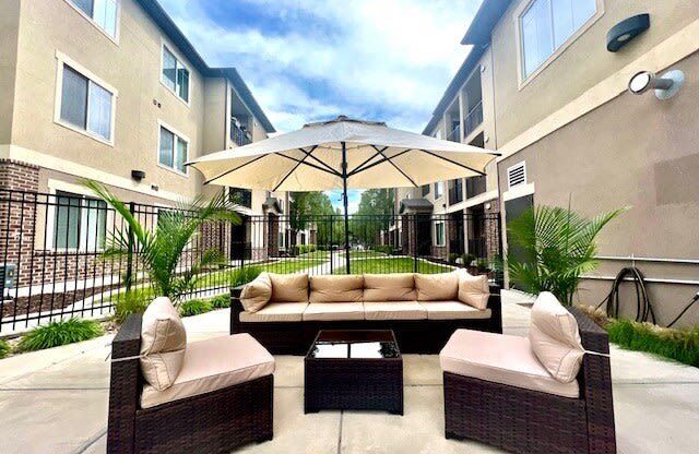 a patio with a couch and an umbrella