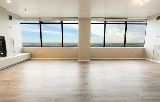 an empty living room with a window view of the city at Apartments at Denver Place, Denver, CO 80202
