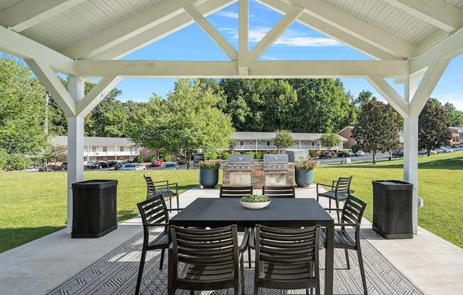 a dining area with a table and chairs under a pavilion