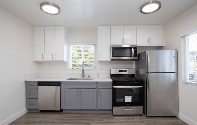 A kitchen with white cabinets and stainless steel appliances.