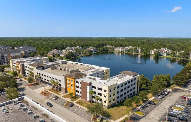 an aerial view of a building next to a lake