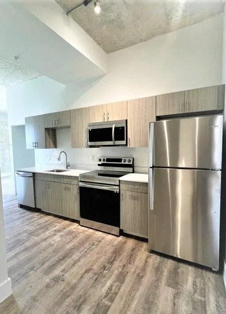 a kitchen with stainless steel appliances and a wooden floor