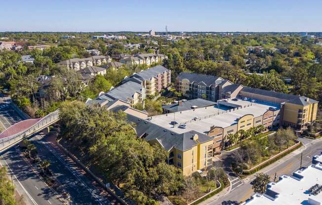 an aerial view of a building with a parking lot and a bridge