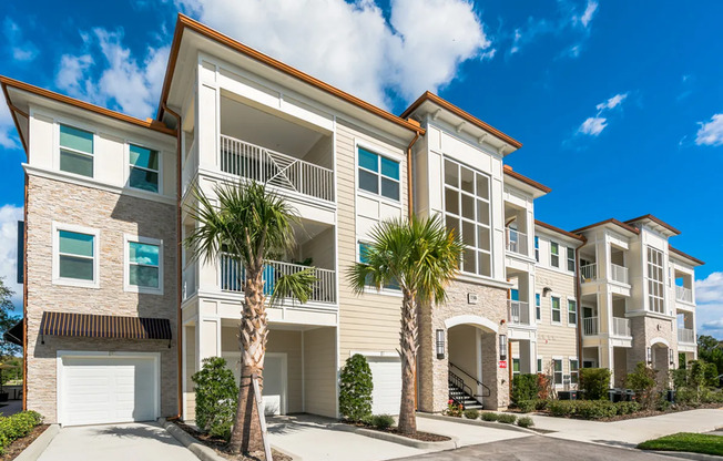 View of Building Exterior, Showing Garages, Landscaping, and Private Patio or Balconies at The Marq Highland Park Apartments