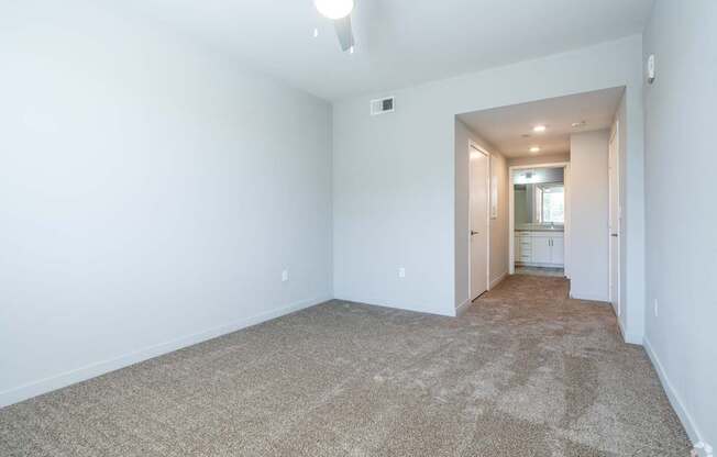 A long hallway with carpeted floors and white walls.