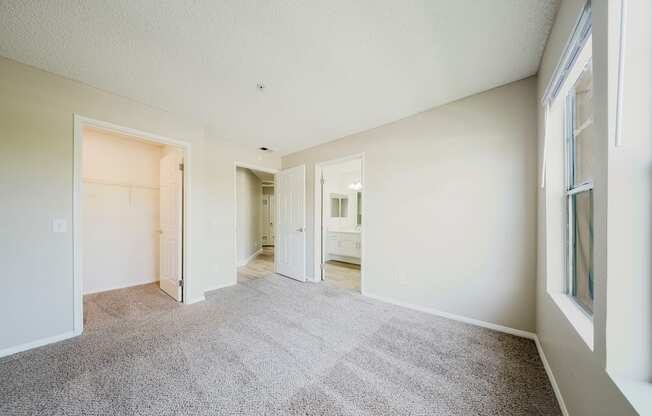 A spacious room with carpeted floor and white walls.